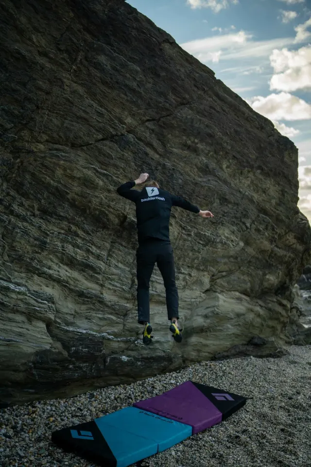 Climber falling onto crash pads with bent knees